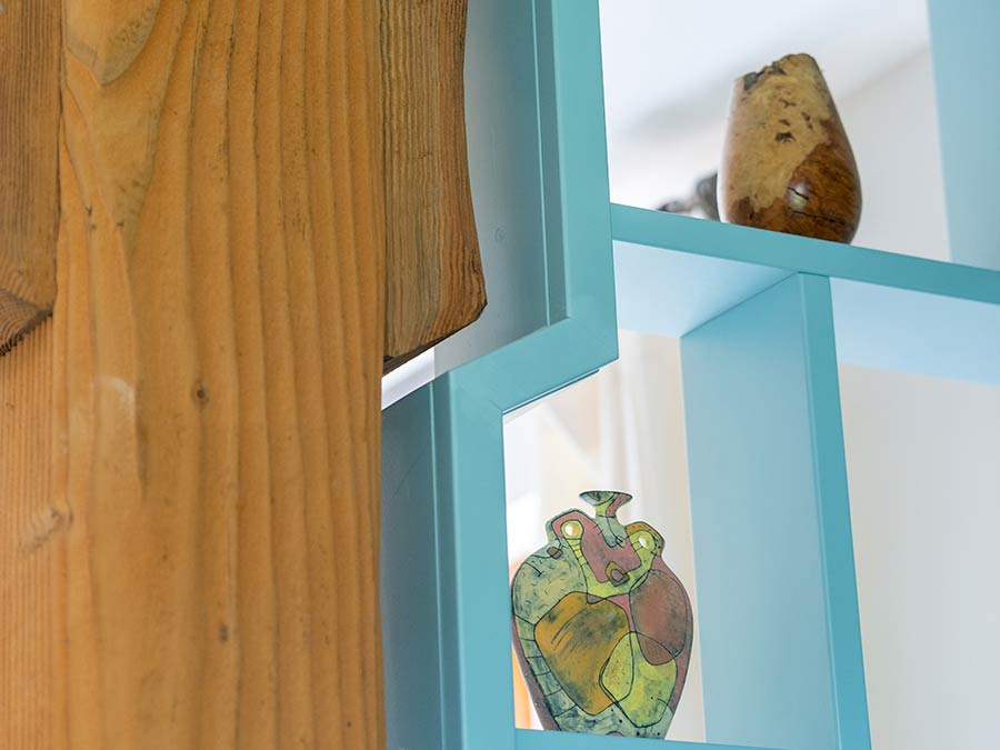 custom cut shelving wrapping around a wood beam in light blue
